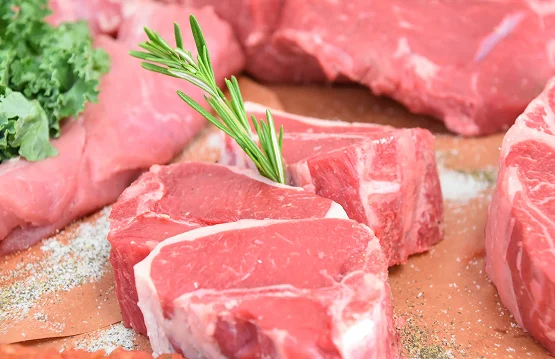 Pork meat. Fresh pork steaks on cutting board with ingredients for cooking.